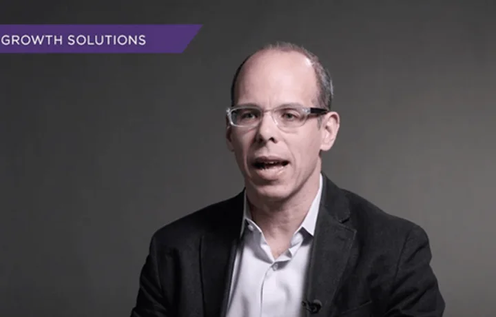 Still from the video series — Professor Michael Mazzeo speaking to camera under a purple “Growth Solutions” title bar.
